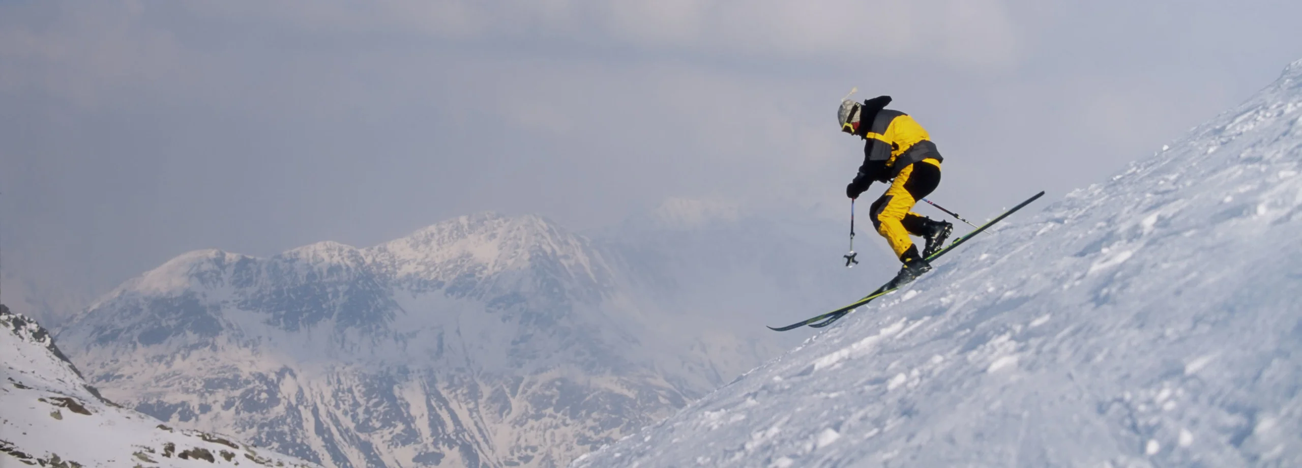 Male adult skier in orange jacket telemark skiing in powder snow in St Anton Austria