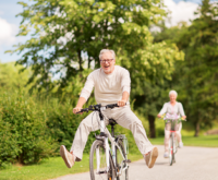 An elderly couple riding bicycle