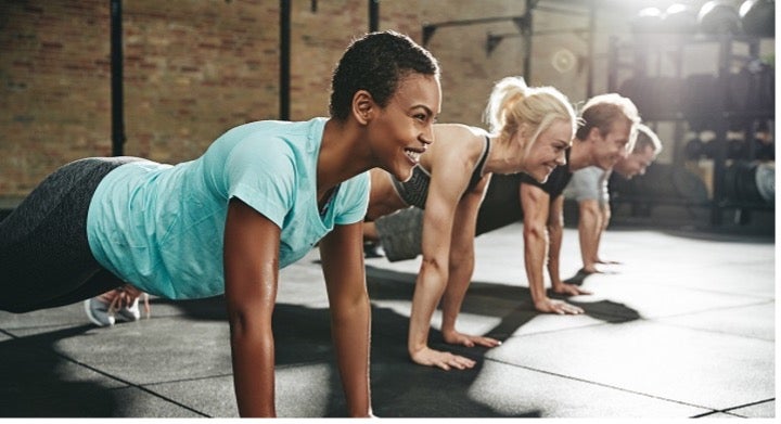 A group of young females excercising in a gym.