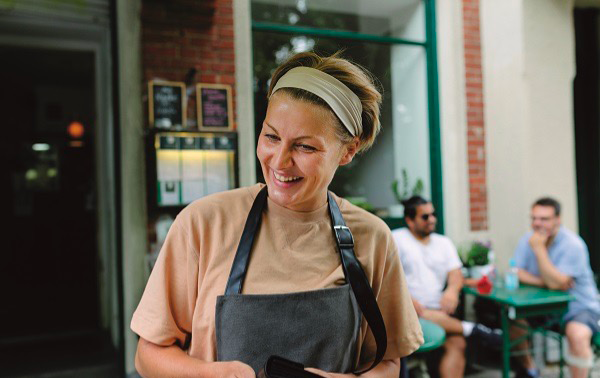 Women in an apron smiling at customers