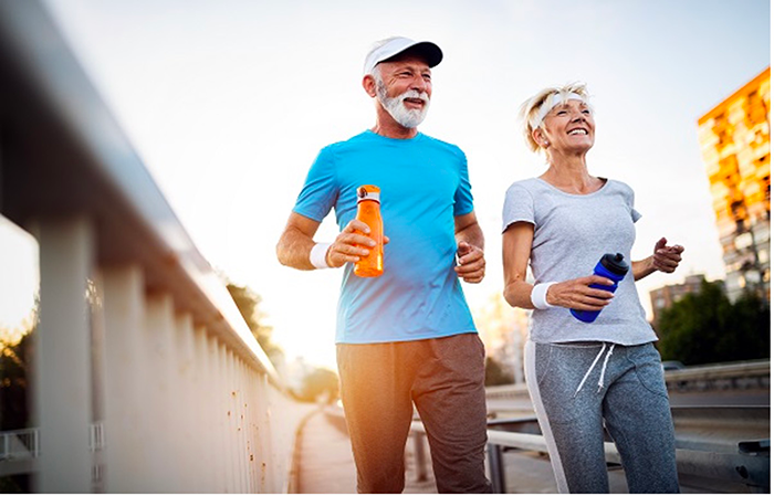 Two elderly people jogging and smiling