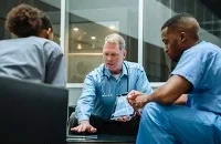 Three healthcare practitioners in deep discussion.