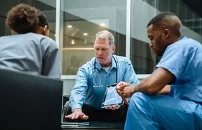 Three healthcare practitioners in deep discussion.