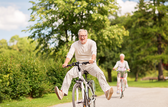 An elderly couple riding bicycle