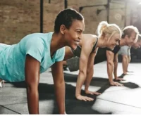 A group of young females excercising in a gym.