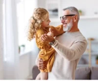 A happy family moment: grandfather dancing with granddaughter