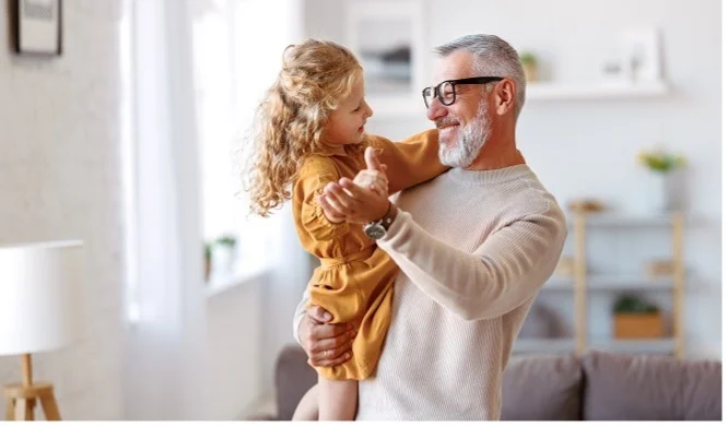 A happy family moment: grandfather dancing with granddaughter