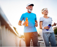 Two elderly people jogging and smiling