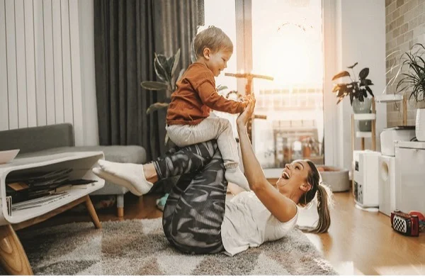 Mother playing with son in the living room