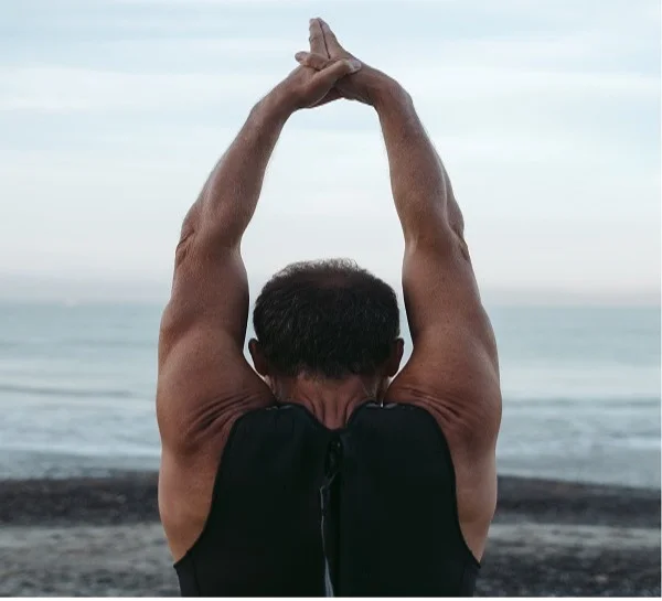 A man practicing yoga on the sea-front