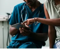 Healthcare practitioners in conversation with a patient.