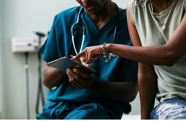 Healthcare practitioners in conversation with a patient.
