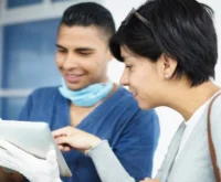 Medical professional and patient reviewing information on a tablet.