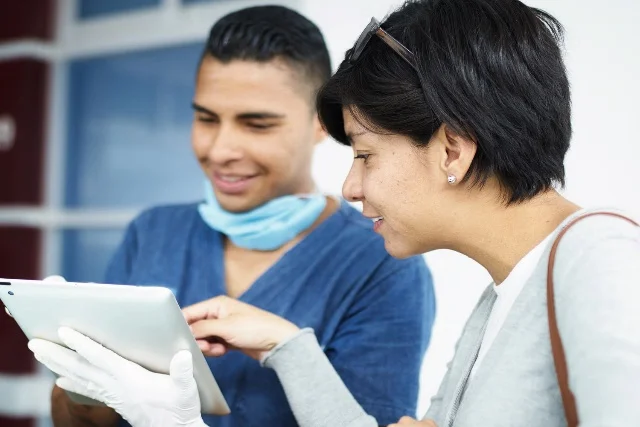 Medical professional and patient reviewing information on a tablet.