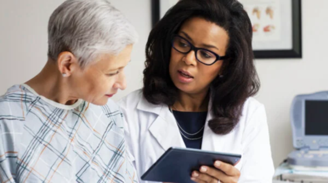 A doctor reviews information with her patient on a tablet