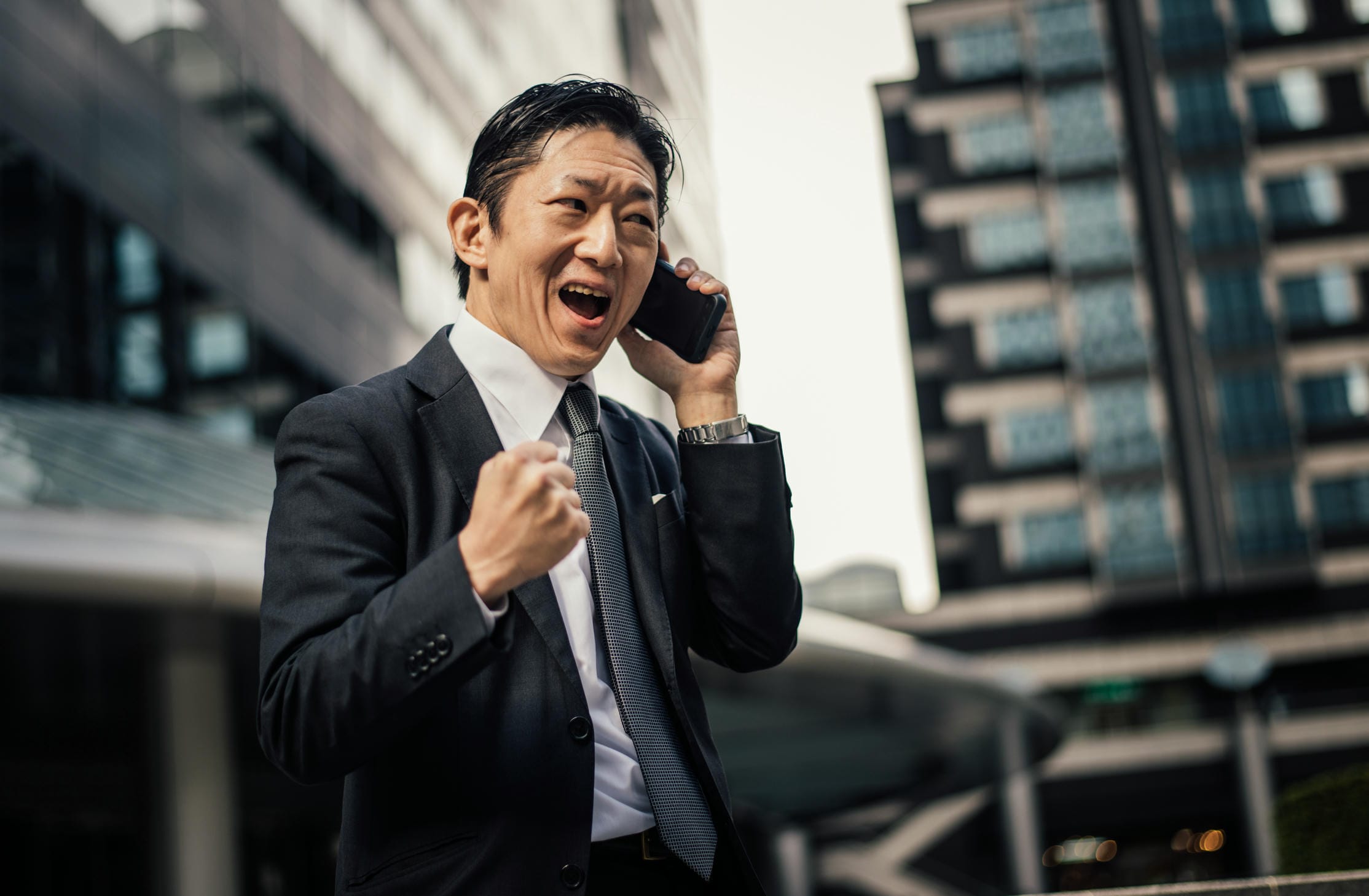 Professional in formal attire talking excitedly on the phone