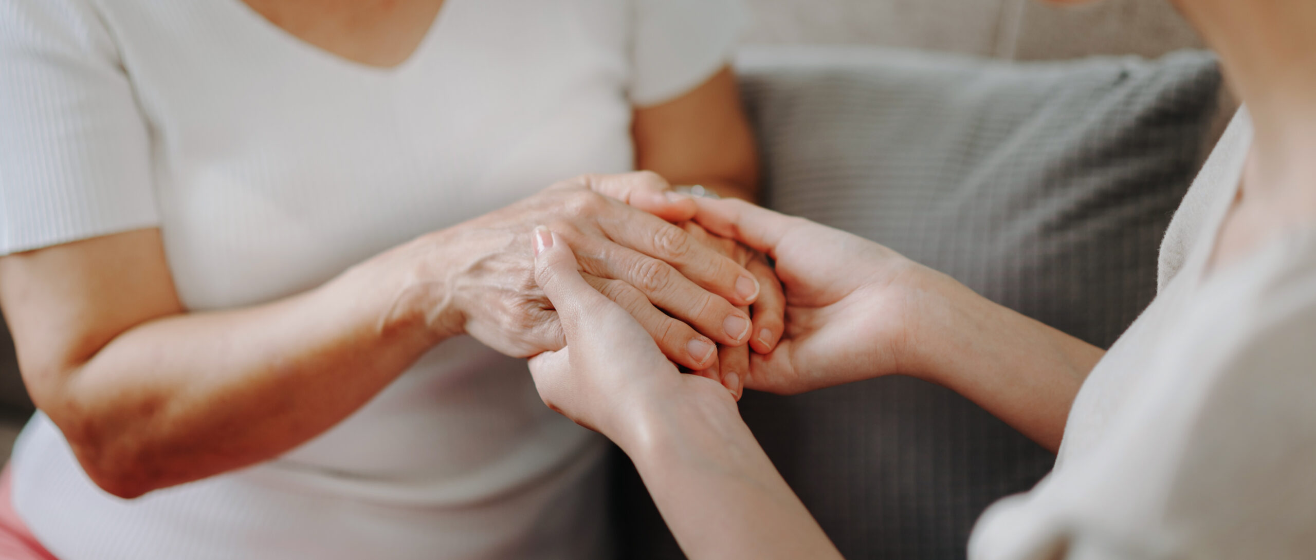 A pair of hands gently supporting another with care.