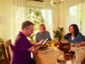 A family at dining table eating and conversing together.