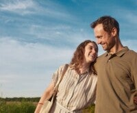 Smiling happy couple taking a walk on a sunny day, looking at each other