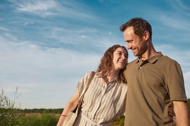 Smiling happy couple taking a walk on a sunny day, looking at each other