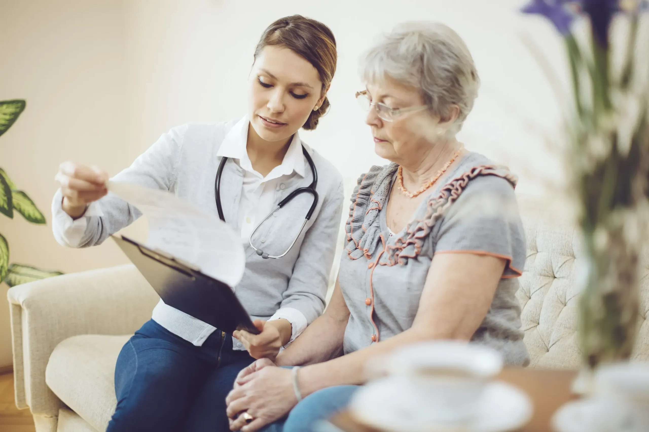 A healthcare professional sits with a patient, holding a document