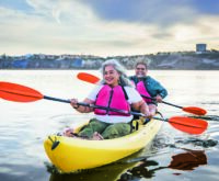 A couple rowing a boat on calm water, embracing their freedom