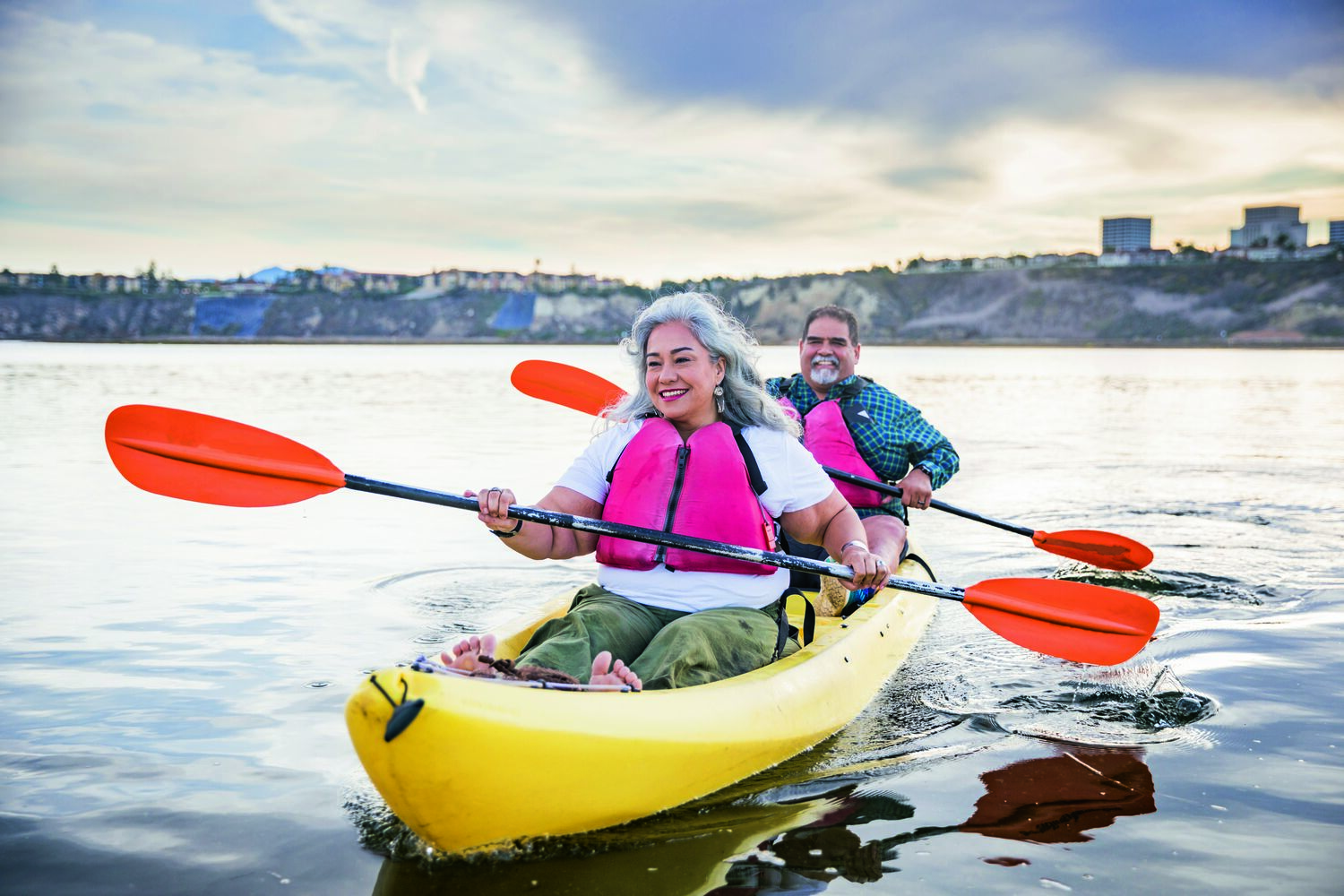 A couple rowing a boat on calm water, embracing their freedom