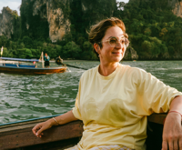 A lady smiling on a boat ride on a bright sunny day
