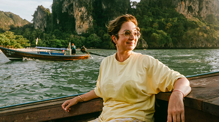 A lady smiling on a boat ride on a bright sunny day
